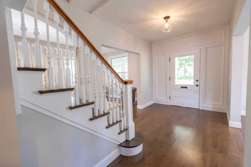 Warm hardwood in an entry hall with a white spindle staircase