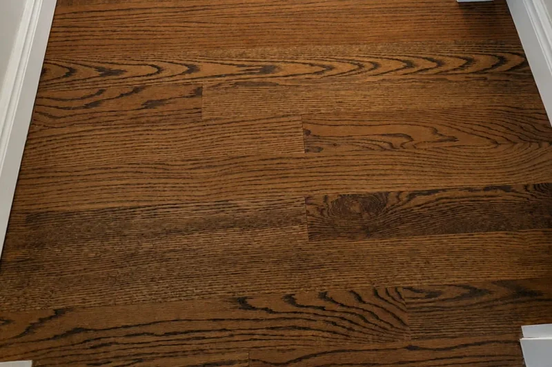 Refinished red oak stair treads and landing matched to the surrounding hardwood flooring