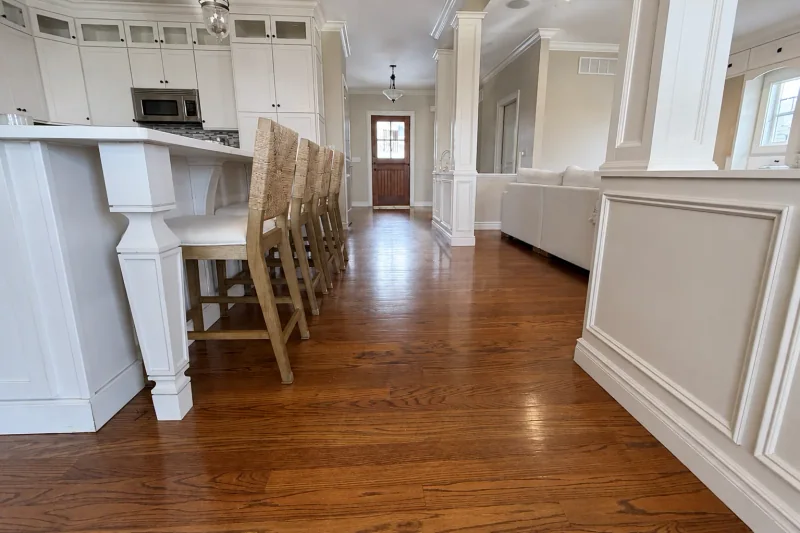 Refinished red oak hardwood flooring running from the kitchen through the hallway to the front door