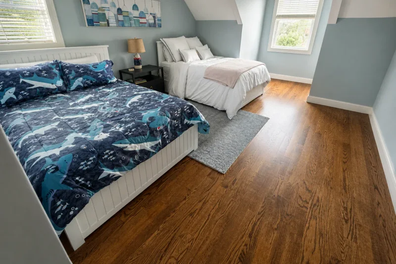 Kids bedroom with two beds and freshly refinished red oak hardwood flooring in a Point Pleasant NJ home