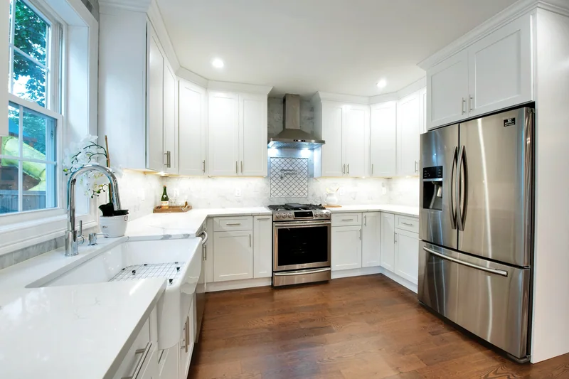 Dark hardwood in a corner kitchen with quartz counters and stainless appliances