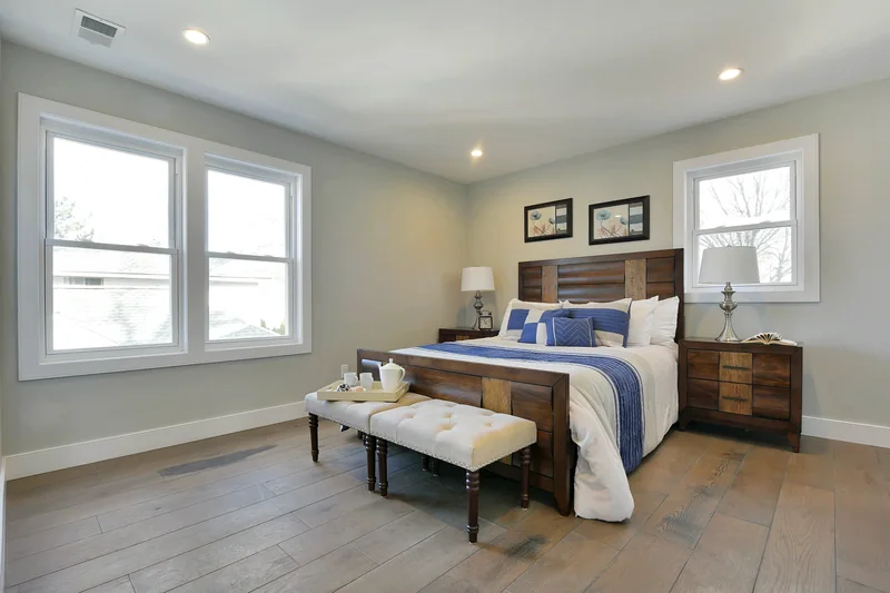 Wide grey-toned hardwood in a staged bedroom with a dark wood headboard