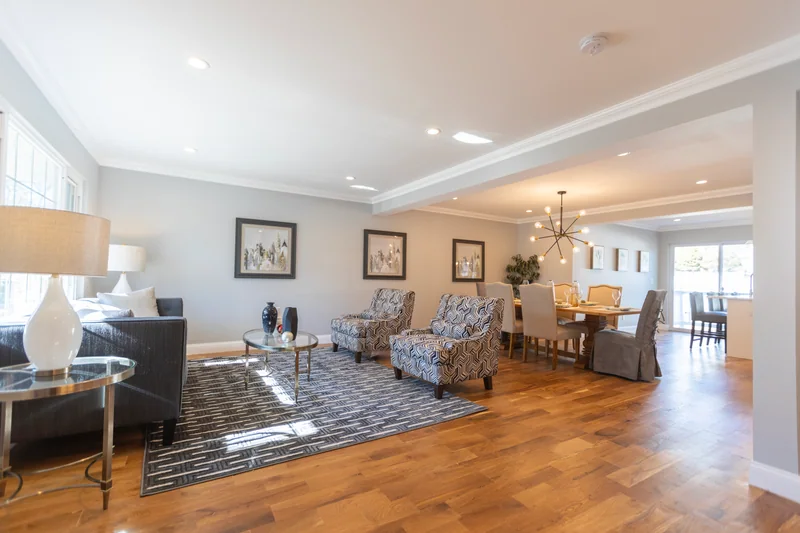 Golden hardwood in a staged living room open to the dining room beyond
