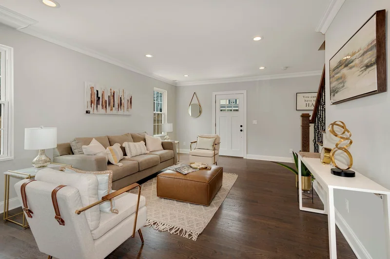 Medium-brown hardwood in a staged living room looking toward the front entry and stair