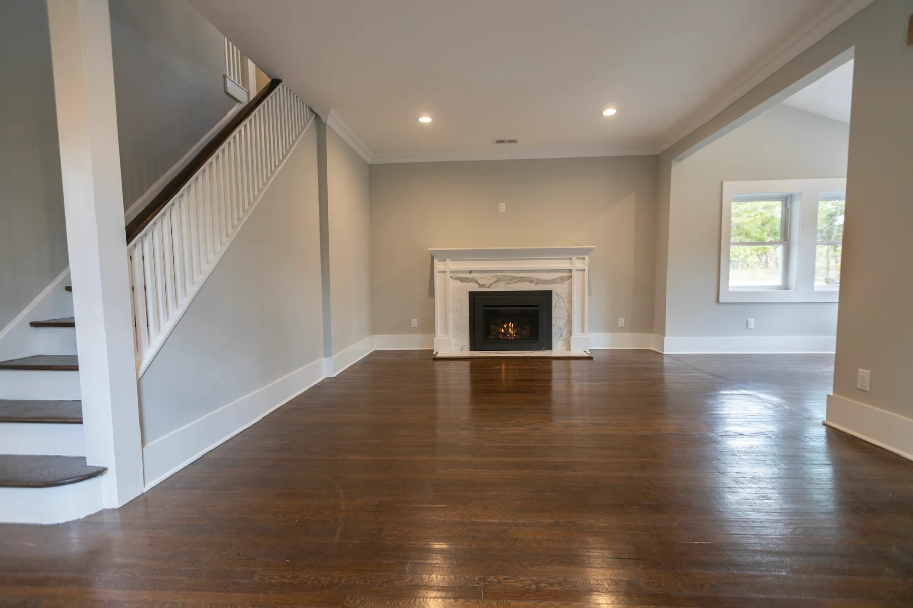 Warm medium-brown oak running past a fireplace and staircase